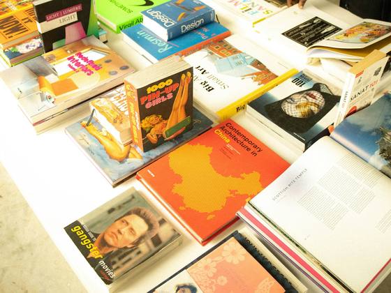 A long white table stacked with bright new paperbacks.